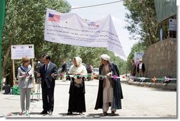 Mrs. Laura Bush, left, assists local officials with the ribbon cutting ceremony June 9, 2008 in Afghanistan at the ground-breaking ceremonies for the 1.96 kilometer Bamiyan road project through the bazaar. The new road will link up with a 1.72 kilometer road from the airport to the town center completed in 2007 with U.S. support. White House photo by Shealah Craighead