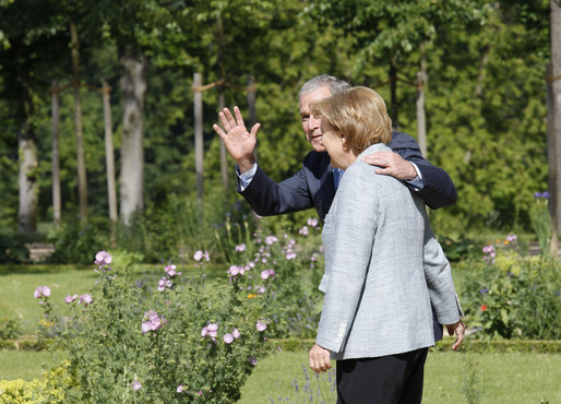 President George W. Bush waves as he walks with German Chancellor Angela Merkel Wednesday, June 11, 2008, during his visit with the fellow leader at Schloss Meseberg, Germany. White House photo by Eric Draper