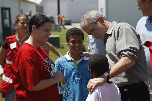President George W. Bush comforts a family displaced by recent flooding during his visit Thursday, June 19, 2008, to a Red Cross shelter in Iowa City, Iowa. White House photo by Eric Draper