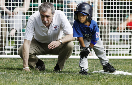 U.S. Secretary of Commerce Carlos Gutierrez coaches a player on third base of the Jose M. Rodriguez Little League Angels of Manati, Puerto Rico, during the 2008 Tee Ball on the South Lawn Season Opener Monday, June 30, 2008, on the South Lawn of the White House. White House photo by Eric Draper