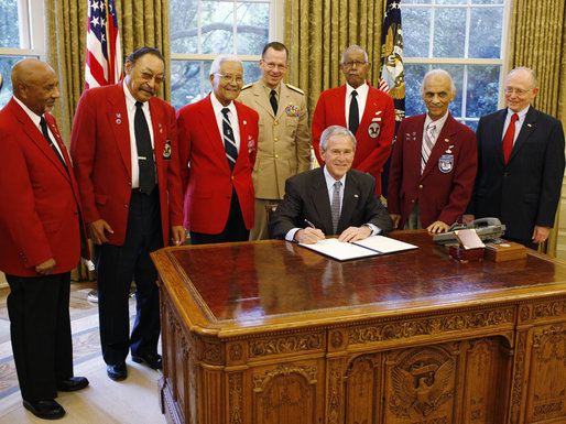 President George W. Bush is joined by members of the Tuskegee Airmen, Joint Chiefs Chairman Admiral Michael Mullen, center-background, and Department of Veterans Affairs Secretary James Peake, right, as he signs a Presidential Proclamation in honor of the 60th Anniversary of Armed Forces Integration, Wednesday, July 23, 2008 in the Oval Office at the White House. White House photo by Eric Draper