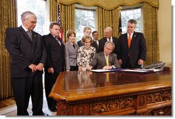 President George W. Bush signs H.J. Res. 93, the Renewal of Import Restrictions on Burma and H.R. 3890, the Tom Lantos Block Burmese JADE Act of 2008, Tuesday, July 29, 2008 in the Oval Office of the White House. President Bush was joined during the signings by, from left, Rep. Don Manzullo, R-Ill.; Rep. Chris Smith, R-N.J.; Mrs. Laura Bush, Annette Lantos, widow of Rep. Tom Lantos; Lantos grandson, Shiloh Tillemann; Rep.Rush Holt, D-N.J.; Rep. Joe Pitts, R-Pa.; and Rep. Peter King, R-N.Y.  White House photo by Eric Draper