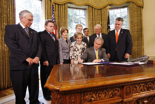 President George W. Bush signs H.J. Res. 93, the Renewal of Import Restrictions on Burma and H.R. 3890, the Tom Lantos Block Burmese JADE Act of 2008, Tuesday, July 29, 2008 in the Oval Office of the White House. President Bush was joined during the signings by, from left, Rep. Don Manzullo, R-Ill.; Rep. Chris Smith, R-N.J.; Mrs. Laura Bush, Annette Lantos, widow of Rep. Tom Lantos; Lantos grandson, Shiloh Tilleman; Rep.Rush Holt, D-N.J.; Rep. Joe Pitts, R-Pa.; and Rep. Peter King, R-N.Y. White House photo by Eric Draper