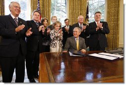 President George W. Bush is applauded after signing H.J. Res. 93, the Renewal of Import Restrictions on Burma and H.R. 3890, the Tom Lantos Block Burmese JADE Act of 2008, Tuesday, July 29, 2008 in the Oval Office of the White House. Applauding President Bush are, from left, Rep. Don Manzullo, R-Ill.; Rep. Chris Smith, R-N.J.; Mrs. Laura Bush, Annette Lantos, widow of Rep. Tom Lantos; Lantos grandson, Shiloh Tillemann; Rep.Rush Holt, D-N.J.; Rep. Joe Pitts, R-Pa.; and Rep. Peter King, R-N.Y.  White House photo by Eric Draper
