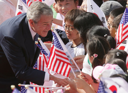 President George W. Bush pauses to greet school children Wednesday, Aug. 6, 2008, during arrival ceremonies at the Blue House, the residence of President Myung-bak Lee of the Republic of Korea, in Seoul. White House photo by Chris Greenberg
