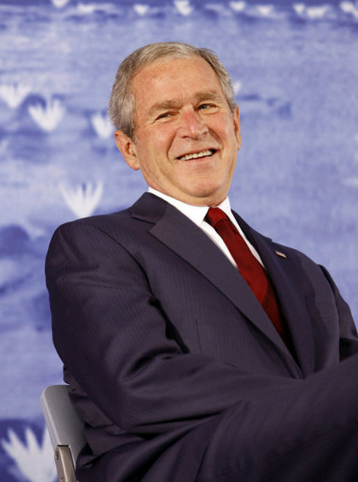President George W. Bush smiles during an introduction by his father, former President George H.W. Bush Friday, Aug. 8, 2008, during the dedication of the United States Embassy in Beijing. White House photo by Eric Draper