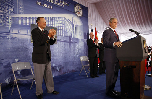 President George W. Bush acknowledges applause after being introduced by former President George H.W. Bush Friday, Aug. 8, 2008, during dedication ceremonies at the U.S. Embassy in Beijing. Said the President, "This has got to be a historic moment: father and son, two Presidents, opening up an embassy. I suspect it's the first, although I must confess I haven't done a lot of research into the itinerary of the Adams boys." White House photo by Eric Draper