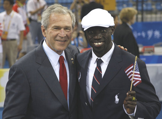 President George W. Bush poses for a photo with U.S. Olympic runner Lopez Lomong Friday, Aug. 8, 2008, in Beijing prior to Opening Ceremonies of the 2008 Summer Olympic Games. Lopez Lomong, a survivor of the violence in his native Sudan, now a U.S. citizen, was selected by his teammates to lead the U.S. Olympic team into Olympic National Stadium carrying the United States Flag at the Opening Ceremony. White House photo by Eric Draper