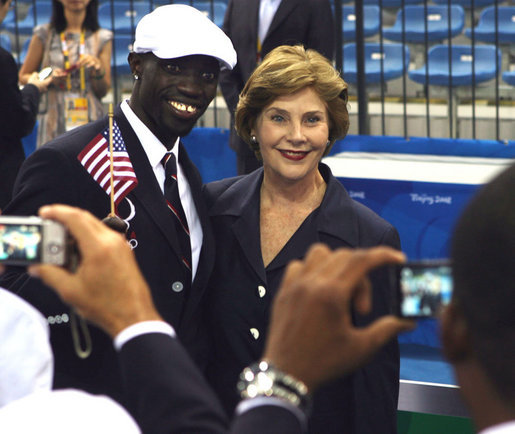 Mrs. Laura Bush with U.S. Flag Bearer Lopez Lomong as she greets members of the U.S. Summer Olympic Team at the Fencing Hall in Beijing on August 8, 2008. Mr. Lomong is a survivor of the violence in his native Sudan. He is now a U.S. citizen and was selected by his teammates to lead the U.S. Olympic team into the Olympic National Stadium carrying the United States Flag at the Opening Ceremony, which followed shortly after this picture was taken. White House photo by Shealah Craighead