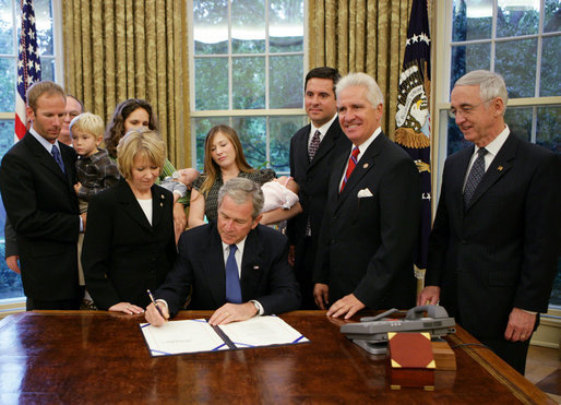 President George W. Bush, joined by members of the Hubbard family, signs H.R. 6580, The Hubbard Act, Friday, Aug. 29, 2008 in the Oval Office of the White House. Also joining the President is Rep. Jim Costa, D-Calif., right of President Bush, Rep. Devin Nunes, R-Calif., right rear, and Deputy Secretary of Defense Gordon England, far right. The Hubbard Act is named in honor of brothers Jared and Nathan Hubbard , who lost their lives serving our country in Iraq. Their brother, Jason Hubbard, was discharged from the Army as a sole survivor but was denied separation benefits. H.R. 6580 will provide sole survivors a number of benefits already offered to other soldiers honorably discharged from military service. White House photo by Chris Greenberg