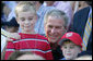 President George W. Bush poses for photos with two youngsters at the Tee Ball on the South Lawn: A Salute to the Troops game Sunday, Sept. 7, 2008, played by the children of active-duty military personnel. White House photo by Chris Greenberg