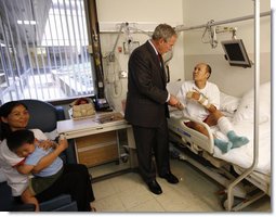 President George W. Bush visits with U.S. Army Sgt. Pengchun Pech of Lynne, Mass., Tuesday, Sept. 9, 2008, at Walter Reed Army Medical Center, where the soldier is recovering from wounds received during Operation Iraqi Freedom. Looking on is his wife, Leakhenavodey Pech, and 22-month-old son, Tommy, sit nearby. White House photo by Eric Draper
