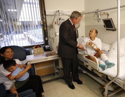 President George W. Bush visits with U.S. Army Sgt. Pengchun Pech of Lynne, Mass., Tuesday, Sept. 9, 2008, at Walter Reed Army Medical Center, where the soldier is recovering from wounds received during Operation Iraqi Freedom. Looking on is his wife, Leakhenavodey Pech, and 22-month-old son, Tommy, sit nearby. White House photo by Eric Draper