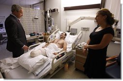 President George W. Bush speaks with Sgt. Besiki Balakhadze, a member of the Georgian Army Coalition Forces, during a visit Tuesday, Sept. 9, 2008, to Walter Reed Army Medical Center in Washington, D.C., where the soldier is recovering from wounds received during Operation Iraqi Freedom. With them is interpreter Staff Sgt. Tatiana Ivanova, also of the Georgian Army Coalition Forces. White House photo by Eric Draper