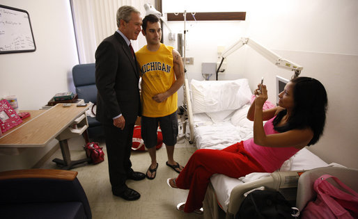 President Bush stands with U.S. Army Spc. Daryl Sullivan of Dyer, Ind., as the soldier's wife, Sarah, takes their photo Tuesday, Sept. 9, 2008, during the President's visit to Walter Reed Army Medical Center in Washington, D.C., where Spc. Sullivan is recovering from wounds received during Operation Iraqi Freedom. White House photo by Eric Draper
