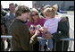 Mrs. Laura Bush offers photos of the Bush family dogs, Scottish Terrier's Barney and Miss Beazley, and the cat, Willie, to a little girl before departing from Forbes Field in Topeka, Kan., on Tuesday, Sept. 16, 2008. She had just greeted members of the military gathered to see her departure from the air field. White House photo by Chris Greenberg