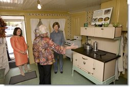 Mrs. Laura Bush receives an explanation of the scale of author Laura Ingalls Wilder's kitchen from Mrs. Jean Coday, Director and President of the Laura Ingalls Wilder Historic Home and Museum in Mansfield, Mo., Oct. 3, 2008. Accompanying the two on the tour is Mrs. Melanie Blunt, First Lady of Missouri. Wilder is one of Mrs. Bush's favorite writers and she was surprised to see the petite kitchen, built to function for the 4-foot-10-inch author.  White House photo by Chris Greenberg