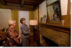 Mrs. Laura Bush looks at a portrait of Laura Ingalls Wilder and her husband on the Wilder home mantle Oct. 3., 2008, in Mansfield, Mo. Laura Ingalls married Almanzo Wilder in the summer of 1885 and moved to the Mansfield home where the "Little House" book series was written in 1894. Mrs. Jean Cody, Director and President of the Laura Ingalls Wilder Historic Home and Museum, explains that the mantle was something that the author really wanted to have. Her husband objected but obviously finally gave in. Wilder, who has been read by children and adults for over 70 years, is one of Mrs. Bush's favorite authors. The visit was used to help encourage American's to read their classic literature which defines us as a nation, reflects our history and bring us together by expressing our shared ideals.  White House photo by Chris Greenberg