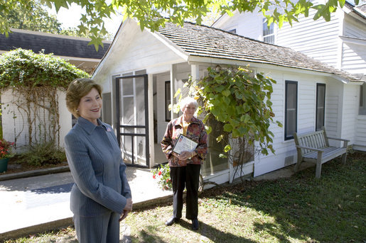 Mrs. Laura Bush talks with press outside the Mansfield, Mo., home of author Laura Ingalls Wilder after Mrs. Jean Coday, Director and President of the Laura Ingalls Wilder Historic Home and Museum, offered the First Lady a tour of the modest home. The home was designated this week as a Save America's Treasures project, which is in partnership with the National Trust for Historic Preservation. Mrs. Bush noted that Wilder, who wrote the "Little House" book series, was one of her favorite authors. "My mother read them to me when I was little before I could read," she said. White House photo by Chris Greenberg