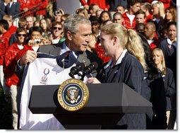 President George W. Bush is presented a team jacket from Paralympian Jennifer Armbruster after delivering his remarks to members of the 2008 United States Summer Olympic and Paralympic Teams Tuesday, Oct. 7, 2008, on the South Lawn of the White House.  White House photo by Eric Draper