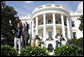 President George W. Bush is joined by Colombian musician Andres Cabas as they wave to invited guests, following Cabas and his band's performance Thursday, Oct. 9, 2008 on the South Lawn of the White House, during the celebration of Hispanic Heritage Month. White House photo by Eric Draper