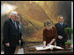Mrs. Laura Bush signs the guest book Oct. 13, 2008 at the National Gallery of Art in Washington as Italian Prime Minister Silvio Berlusconi waits to sign as well. At left is Mr. Rusty Powell, Director of the National Gallery of Art, who led the tour. The Mt. Vesuvius mural is one of the backdrops for the exhibit. White House photo by Joyce N. Boghosian