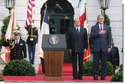 President George W. Bush and Prime Minister Silvio Berlusconi stand together on the reviewing stand Monday, Oct. 13, 2008 on the South Lawn of the White House, during the playing of the National Anthem. White House photo by Chris Greenberg