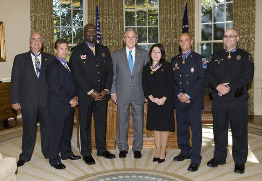 President George W. Bush poses for a photo with the recipients of the Public Safety Officer Medal of Valor Wednesday, Oct. 22, 2008, in the Oval Office at the White House. The Medal of Valor is awarded to public safety officers for extraordinary valor above and beyond the call of duty. White House photo by Chris Greenberg