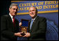 President George W. Bush is presented with an honorary FBI Special Agent credential by FBI Director Robert Mueller Thursday, Oct. 30, 2008, at the graduation ceremony for FBI special agents in Quantico, Va. White House photo by Joyce N. Boghosian