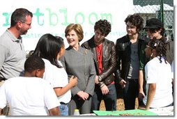 Surrounded by children participating in a soil sampling event, Mrs. Laura Bush speaks with Benjamin Jones, Director of Education, Trinity River Audubon Center, left during the First Bloom event at the Trinity River Audubon Center Sunday, November 2, 2008, in Dallas, TX. Mrs. Bush is joined by singer/songwriters the Jonas Brothers, Kevin Jonas, Joe Jonas, and Nick Jonas, right.  White House photo by Chris Greenberg
