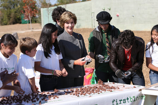 Surrounded by children Mrs. Laura Bush practices making seed balls during a First Bloom event at the Trinity River Audubon Center, Sunday, November 2, 2008, in Dallas, TX. Mrs. Bush is joined by singer/songwriters the Jonas Brothers, Kevin Jonas, Joe Jonas, and Nick Jonas, right. White House photo by Chris Greenberg