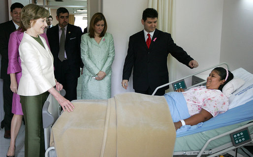 Mrs. Laura Bush spends a moment with Ms. Nancy Villarreal, a breast cancer patient recovering from recent reconstructive surgery, during a visit Friday, Nov. 21, 2008, to the National Oncology Institute in Panama City. Joining her is Mrs. Vivian Fernandez de Torrijos, First Lady of Panama, in pink, and Dr. Rosario Turner, Panama's Minister of Health. The man at right is unidentified. White House photo by Joyce N. Boghosian