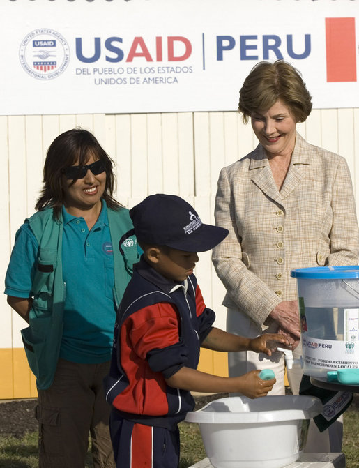 Mrs. Laura Bush and Ms. Nancy Quispitupa, Program Manager and Community Trainer, watch as 8-year-old William Sebastian Hernandez Jeri demonstrates learned hand-washing techniques Friday, Nov. 21, 2008, at the San Clemente Health Center in San Clemente, Peru. The center is the town's major health provider and serves an average of 80 patients per day. White House photo by Joyce N. Boghosian