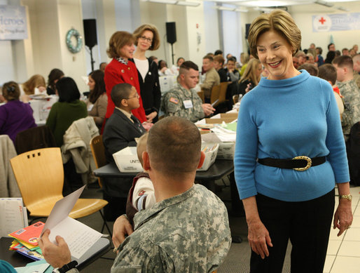 Mrs. Laura Bush greets one of the military volunteers and his child during the Saturday, Dec. 6, 2008, American Red Cross Holiday Mail for Heroes event in Washington, D.C. Standing in the background are American Red Cross President and CEO Gail McGovern, in red, and Bonnie McElveen-Hunter, Chairman of the American Red Cross. As the room full of volunteers sorted cards created by Americans to send to U.S. troops deployed around the world, Mrs. Bush encouraged Americans to do volunteer work in their home towns for those in need of food, care or appreciation. Cards for the troops can still be sent until December 10th at designated post office boxes. White House photo by Chris Greenberg