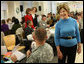 Mrs. Laura Bush greets one of the military volunteers and his child during the Saturday, Dec. 6, 2008, American Red Cross Holiday Mail for Heroes event in Washington, D.C. Standing in the background are American Red Cross President and CEO Gail McGovern, in red, and Bonnie McElveen-Hunter, Chairman of the American Red Cross. As the room full of volunteers sorted cards created by Americans to send to U.S. troops deployed around the world, Mrs. Bush encouraged Americans to do volunteer work in their home towns for those in need of food, care or appreciation. Cards for the troops can still be sent until December 10th at designated post office boxes. White House photo by Chris Greenberg
