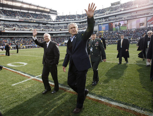 President George W. Bush walks onto the playing turf at Philadelphia's Lincoln Financial Field with U.S. Secretary of Defense Robert Gates Saturday, Dec. 6, 2008, for the 2008 Army-Navy game. The rivalry, a tradition since 1908, was won by the Midshipmen, who delivered a 28-0 shutout to the Black Knights. White House photo by Eric Draper