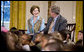 Mrs. Laura Bush and President George W. Bush sit with youngsters Monday, Dec. 8, 2008, during the Children's Holiday Reception and Performance in the East Room of the White House. White House photo by Eric Draper