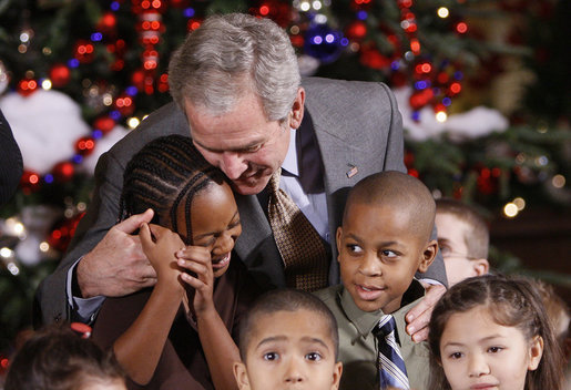 President George W. Bush embraces a group of youngsters Monday, Dec. 8, 2008, as he welcomes children attending the Children's Holiday Reception and Performance at the White House. White House photo by Eric Draper