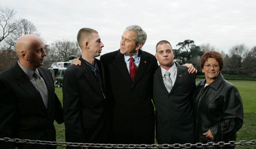President George W. Bush pauses to greet Marine Lance Cpl. Patrick Paul Pittman Jr., left, and Lance Cpl. Marc E. Olson, both wounded in Operation Iraqi Freedom, as he arrived on the South Lawn of the White House Tuesday, Dec. 9, 2008, after spending the day at West Point. With them are Patrick Paul Pittman Sr., father of Lance Cpl. Pittman, and Janice Kloski, mother of Lance Cpl. Olson. White House photo by Joyce N. Boghosian
