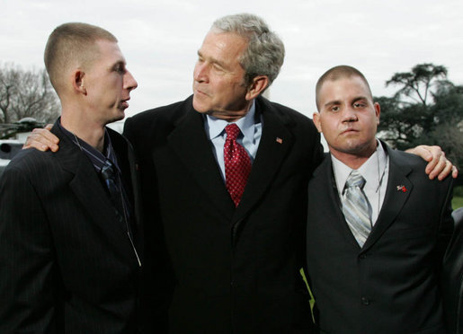 President George W. Bush pauses to greet Marine Lance Cpl. Patrick Paul Pittman Jr., left, and Lance Cpl. Marc E. Olson, both wounded in Operation Iraqi Freedom, as he arrived on the South Lawn of the White House Tuesday, Dec. 9, 2008, after spending the day at West Point. The Marines were on hand to greet the President upon his return. White House photo by Joyce N. Boghosian