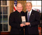 President George W. Bush stands with Father Tim Scully, CSC, after presenting him with the 2008 Presidential Citizens Medal Wednesday, Dec. 10, 2008, in the Oval Office of the White House. White House photo by Chris Greenberg