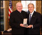 President George W. Bush stands with Father John P. Foley, S.J., after presenting him with the 2008 Presidential Citizens Medal Wednesday, Dec. 10, 2008, in the Oval Office of the White House. White House photo by Chris Greenberg