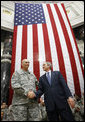 President George W. Bush stands on stage with U.S. Commander in Iraq, General Ray Odierno, Sunday, Dec. 14, 2008, following his address to U.S. military and diplomatic personnel at the Al Faw Palace-Camp Victory in Baghdad. White House photo by Eric Draper