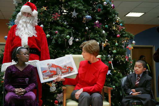 Mrs. Laura Bush reads "My Penguin Osbert" Monday, Dec. 15, 2008 to a gathering of patients and their families at Children's National Medical Center in Washington, D.C. Sitting with her are patient escort volunteers Dania Jecty, left, age 11, and Elmer Reyes, age 13. White House photo by Joyce N. Boghosian
