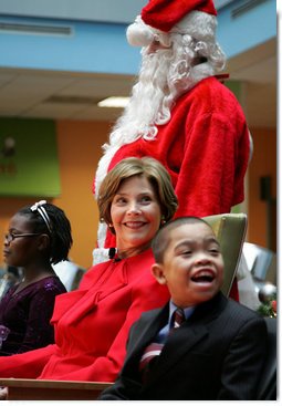 Mrs. Laura Bush watches Barney Cam VII: A Red, White & Blue Christmas as it debuts for children at Children's National Medical Center in Washington, D.C. on Dec. 15, 2008. With Mrs. Bush are her two patient escort volunteers, Dania Jecty, left, age 11, and Elmer Reyes, age 13. Visiting the hospital is an annual tradition for Mrs. Bush, and one she says she will miss.  White House photo by Joyce N. Boghosian