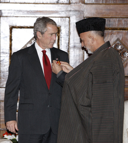 President George W. Bush is presented the Ghazi Amir Amanullah Khan Insignia by Afghanistan's President Hamid Karzai Monday, Dec. 15, 2008, for his efforts in rebuilding the country. The presentation came during a surprise visit to Kabul about which the President said, "I want to be in Afghanistan to say 'thank you' to President Karzai, to let the people of Afghanistan know that the United States has stood with them and will stand with them." White House photo by Eric Draper