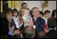 President George W. Bush holds 14-month-old Trey Jones of Cypress, Texas, following his remarks about stem cell research policy legislation in the East Room of the White House Wednesday, July 19, 2006. White House photo by Kimberlee Hewitt