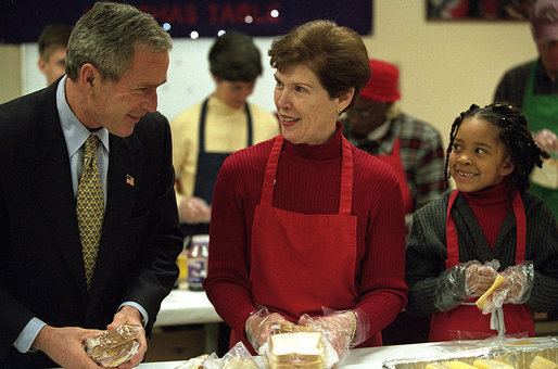 President George W. Bush talks with volunteer Connie Jeremiah as he helps pack sandwiches Dec. 20, 2001, at Martha's Table, center for homeless adults and children in Washington, D.C. White House photo by Eric Draper