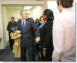 With Mrs. Laura Bush by his side, President George W. Bush speaks to reporters Monday, Dec. 22, 2008, during a visit to the Pathways to Housing DC, a distribution site for the One Warm Coat Holiday Service Project, in Washington, D.C. Modeled after the first Pathways to Housing program in New York City founded in 1992, Pathways to Housing DC works with individuals who have been turned away from other programs.  White House photo by Shealah Craighead