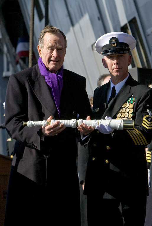 Former President George H.W. Bush presents a long glass to the First Officer of the Deck to set the first watch Saturday, Jan. 10, 2009, during commissioning ceremonies for the USS George H.W. Bush (CVN 77) aircraft carrier in Norfolk, Va. White House photo by David Bohrer